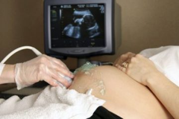 A pregnant mother receiving maternity services by getting an ultrasound scan checkup